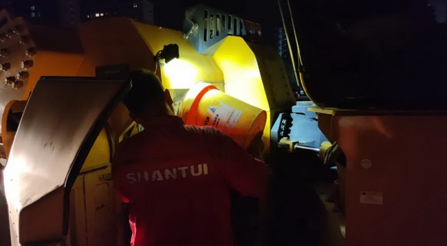 服务人员深夜为压路机做保养 服务人员深夜为压路机做保养